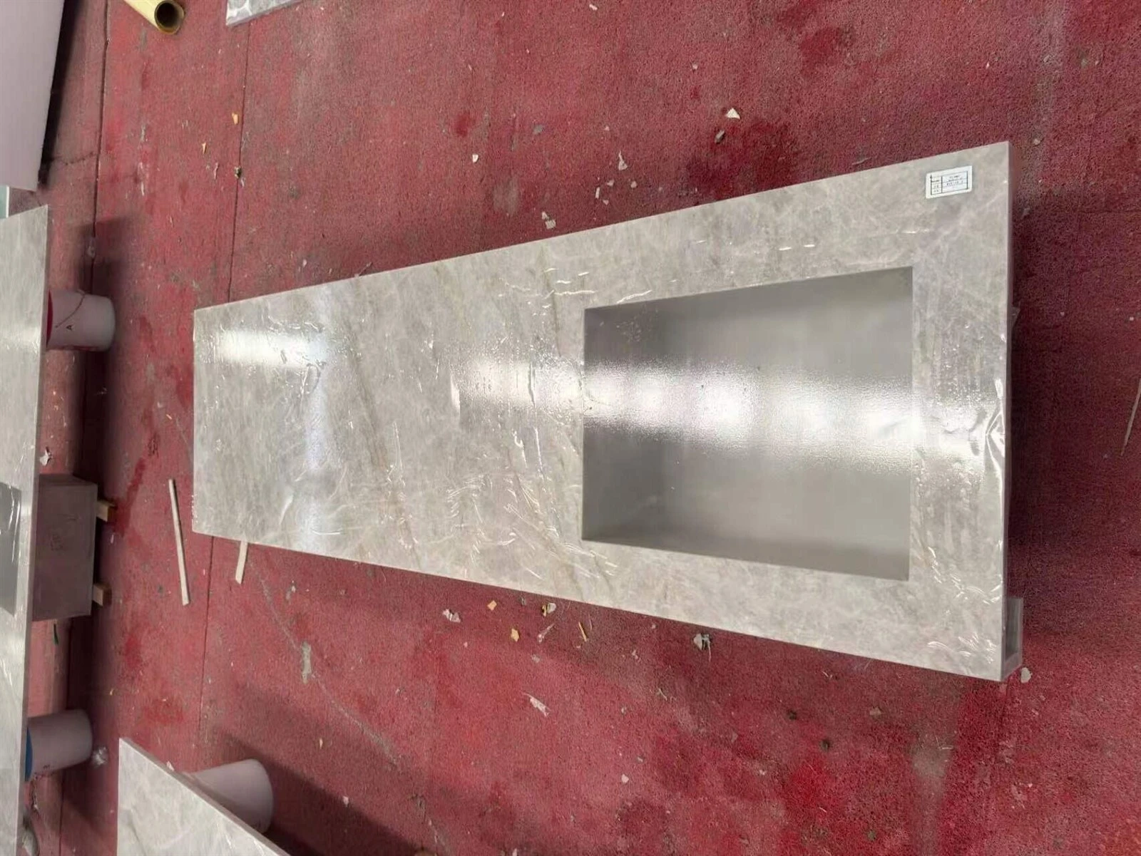 Finished Taj Mahal Quartzite countertop with integrated rectangular sink and protective surface film in the fabrication workshop. Finished Taj Mahal Quartzite countertop with integrated rectangular sink and protective surface film in the fabrication workshop.